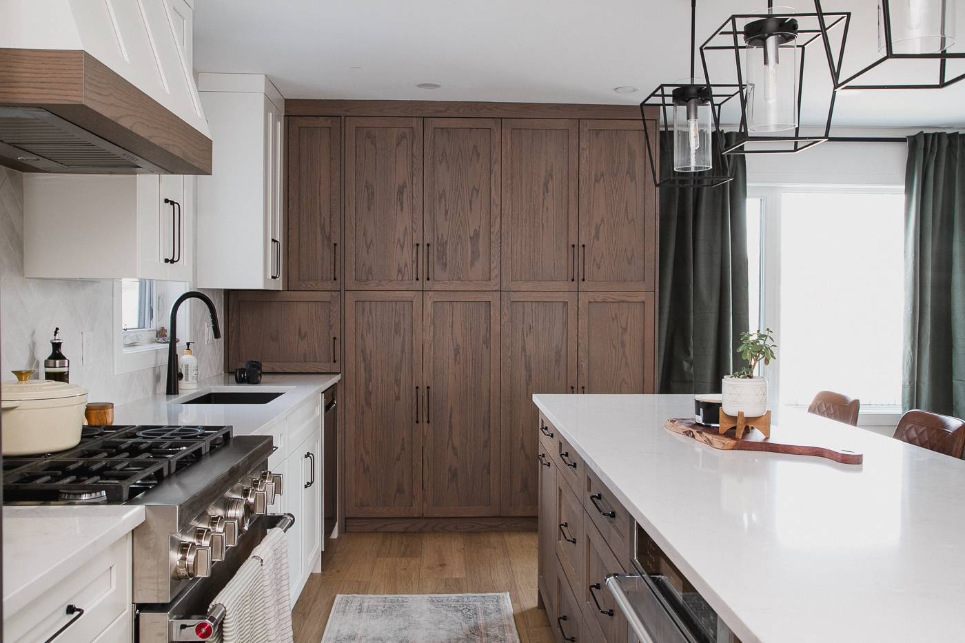 Spacious kitchen with wood cabinetry, large island, and pendant lights. in Calgary | Kavaleer Renovations