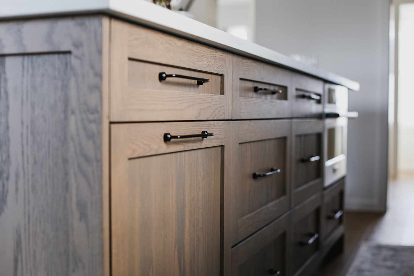 Close-up of wood kitchen island drawers with black pulls. in Calgary | Kavaleer Renovations Close-up of wood kitchen island drawers with black pulls. in Calgary | Kavaleer Renovations