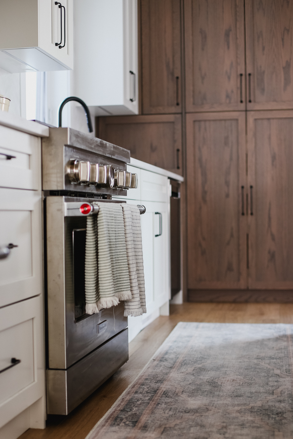 Stainless steel oven with striped tea towels and wood cabinetry. in Calgary | Kavaleer Renovations Stainless steel oven with striped tea towels and wood cabinetry. in Calgary | Kavaleer Renovations