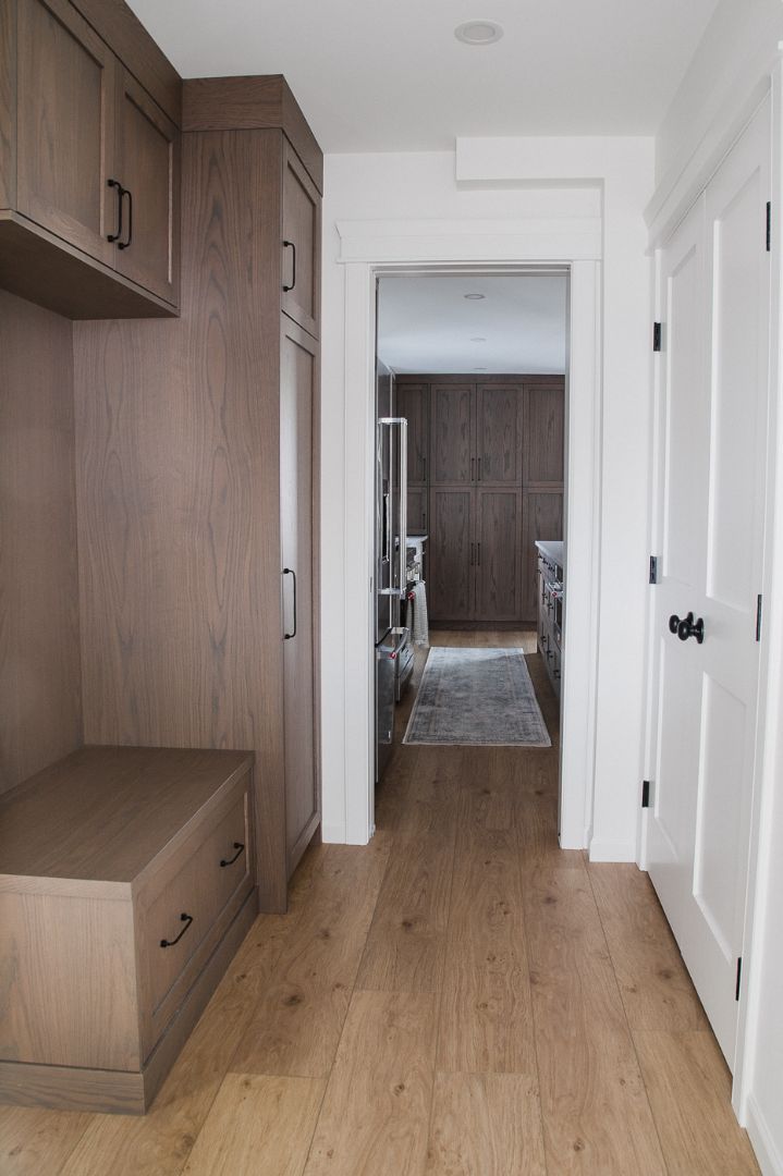 Hallway with wood built-in storage leading into modern kitchen. in Calgary | Kavaleer Renovations Hallway with wood built-in storage leading into modern kitchen. in Calgary | Kavaleer Renovations