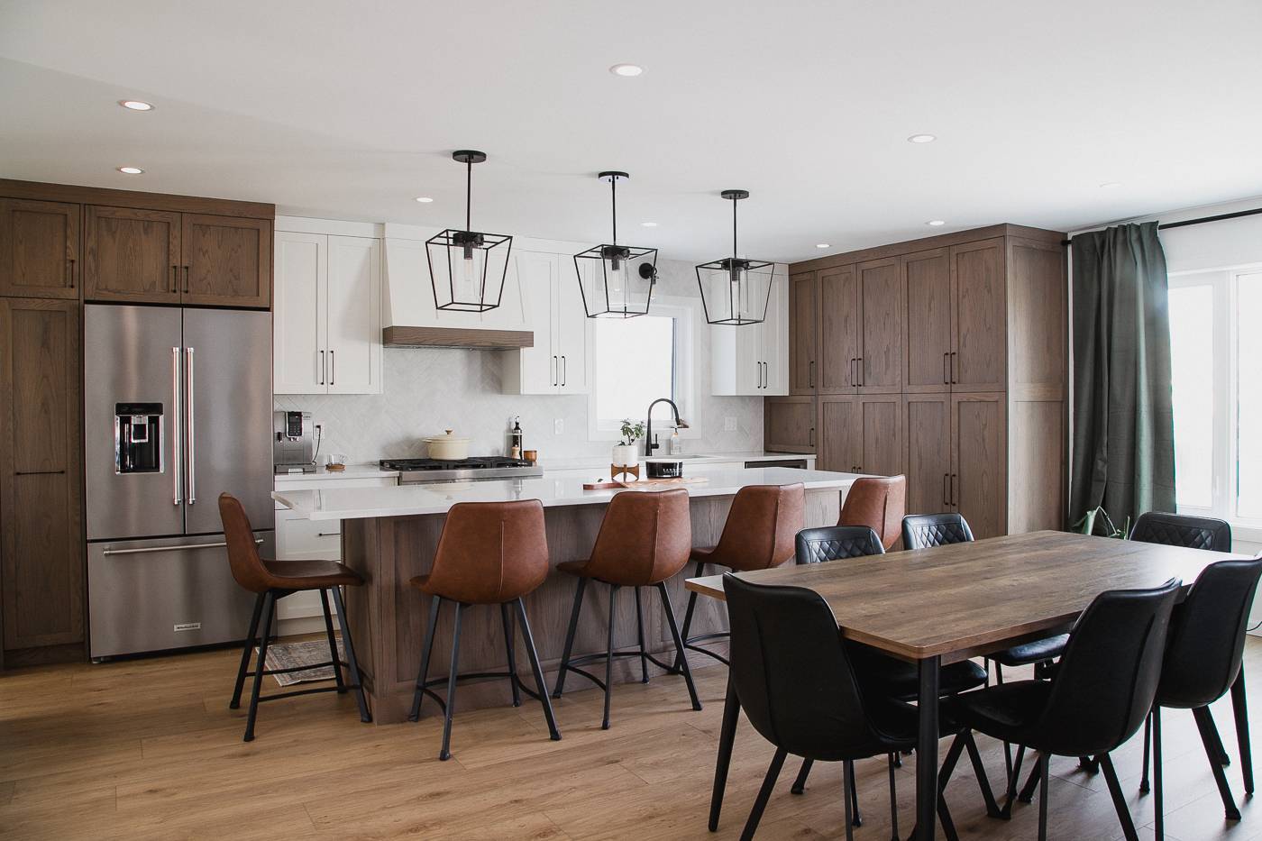 Full kitchen and dining area with wood accents and seating for ten. in Calgary | Kavaleer Renovations